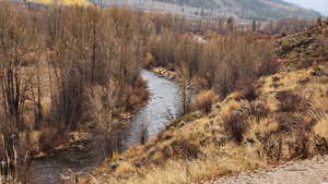 View of mountain backdrop with a large body of water and a heavily wooded area