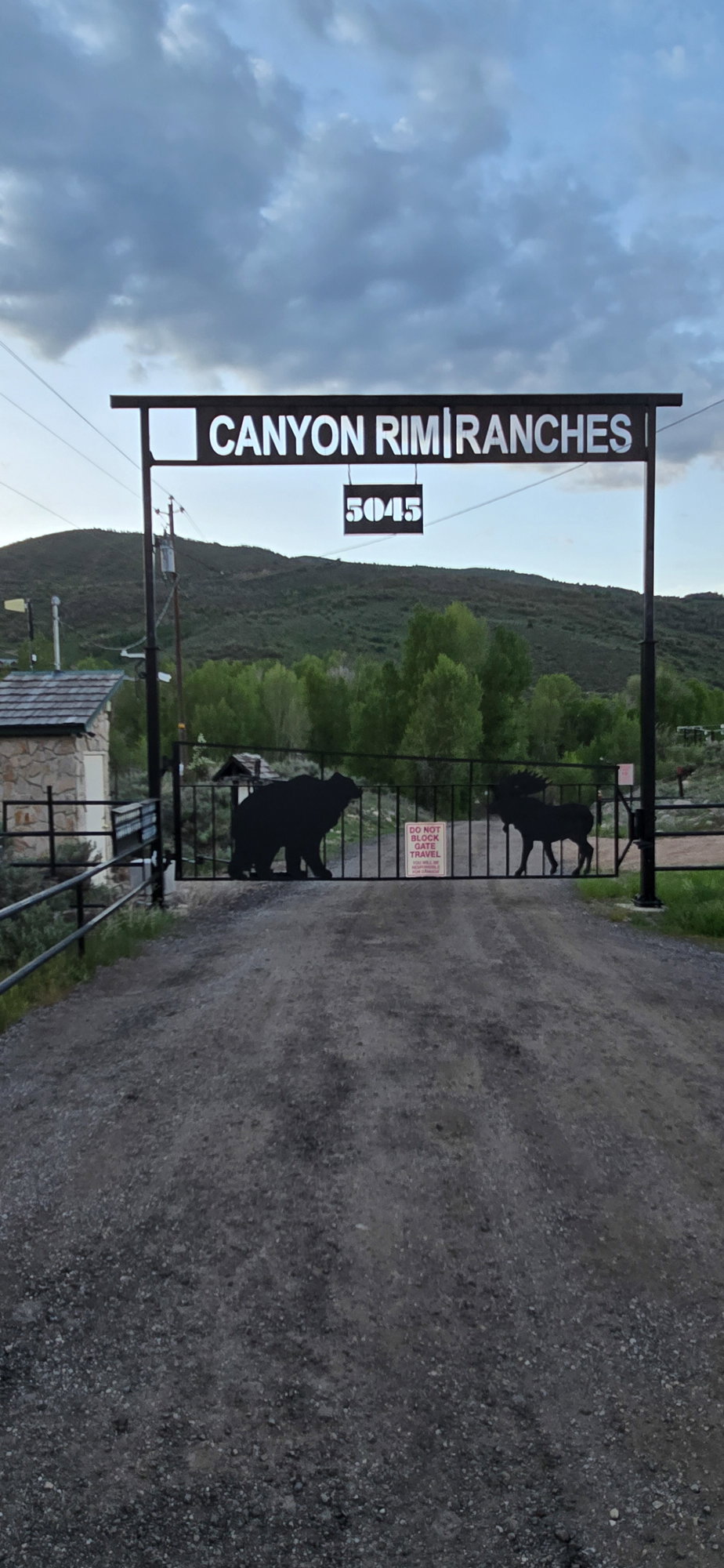 View of road featuring a view of countryside, a gated entry, and a gate