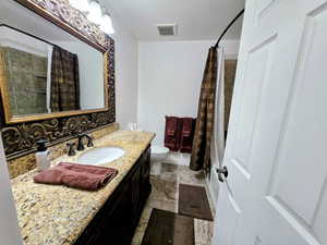 Full bathroom with vanity, a textured ceiling, and shower / tub combo with curtain