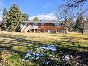 Rear view of house with stairs, a deck, and brick siding
