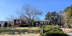 Ranch-style house featuring brick siding and a front yard