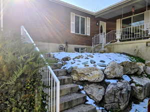 View of property exterior with brick siding and stairway