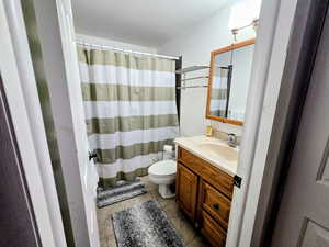 Full bathroom with a shower with shower curtain, vanity, and light tile patterned flooring