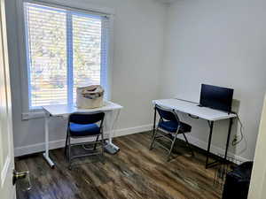 Office space featuring dark wood-style flooring and baseboards