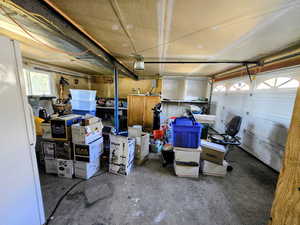 Garage featuring freestanding refrigerator and a garage door opener