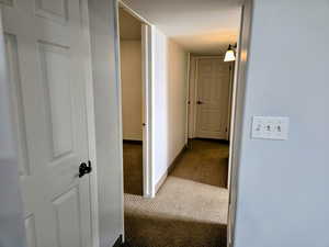 Corridor featuring carpet floors and baseboards