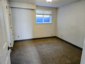 Carpeted spare room with baseboards