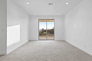 Unfurnished room with light colored carpet and recessed lighting