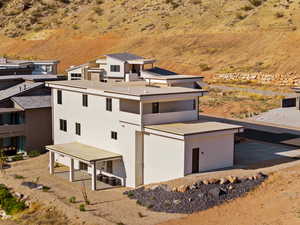 View of property exterior featuring a patio area, stucco siding, and view of desert landscape