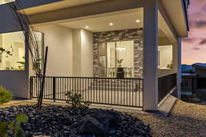 Property entrance with stone siding and stucco siding