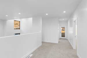 Corridor featuring recessed lighting and light carpet