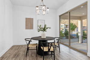 Dining area with wood finished floors, a chandelier, and recessed lighting