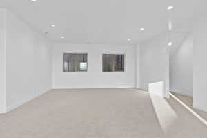 Empty room featuring light carpet and recessed lighting