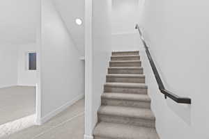 Staircase featuring carpet and recessed lighting