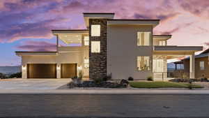 Contemporary home with stucco siding, stone siding, and concrete driveway