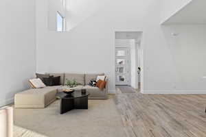 Living room featuring a high ceiling and light wood-style floors