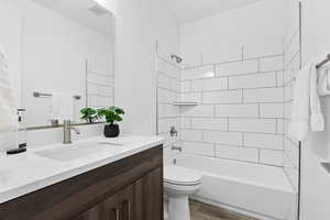 Full bathroom with vanity, bathing tub / shower combination, and wood finish floors