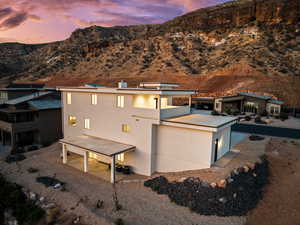 Back of property at dusk with a patio area, stucco siding, and a mountain view