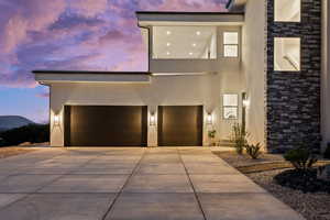 Contemporary house with stucco siding, driveway, and stone siding
