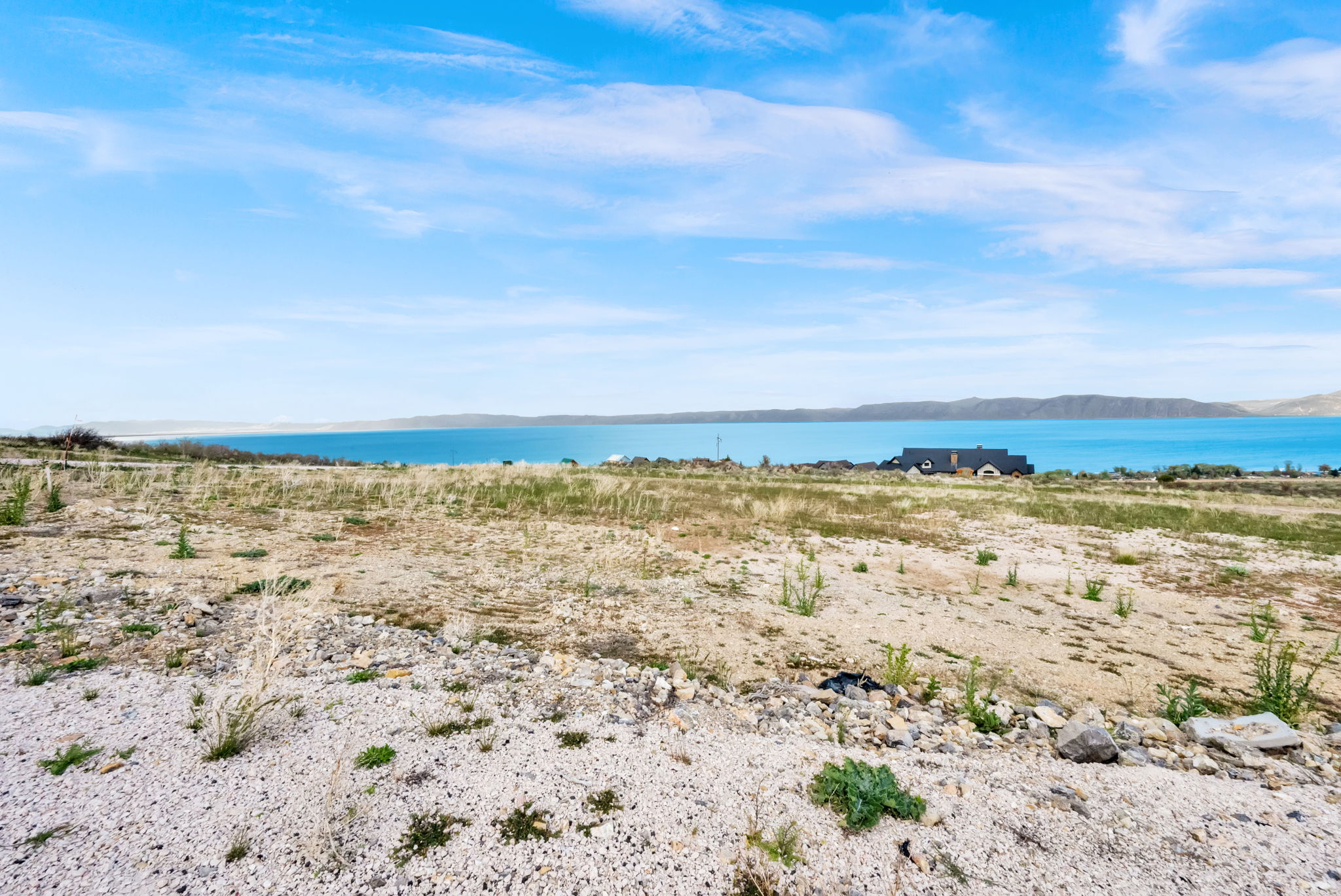 Expansive land parcel featuring natural terrain and a distant body of water