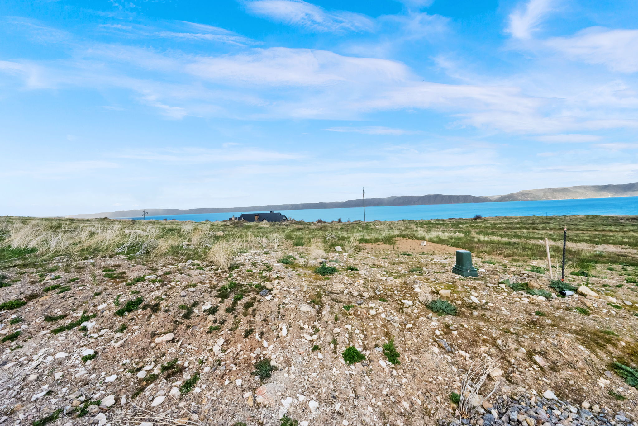 Expansive land parcel featuring natural terrain and a distant water body