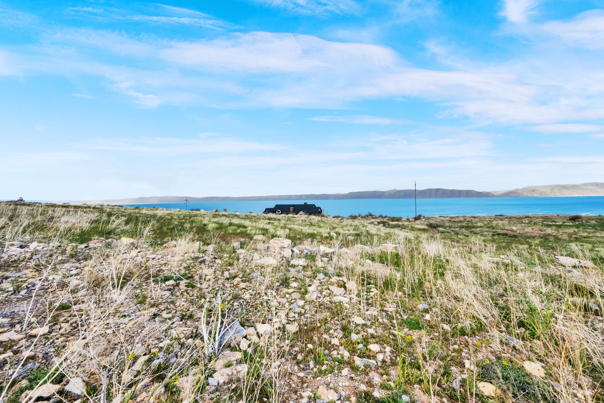 Expansive land parcel featuring natural grasses and scattered rock formations