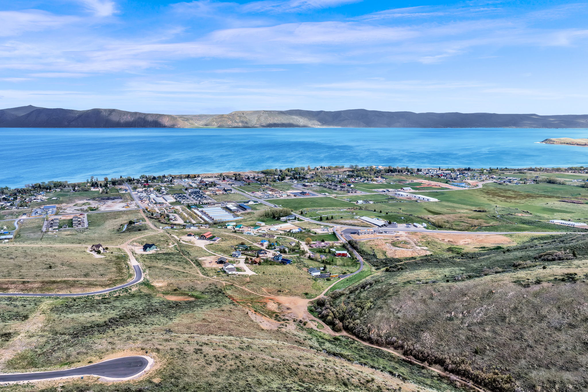 Expansive aerial perspective showcasing a significant body of water bordered by mountainous terrain