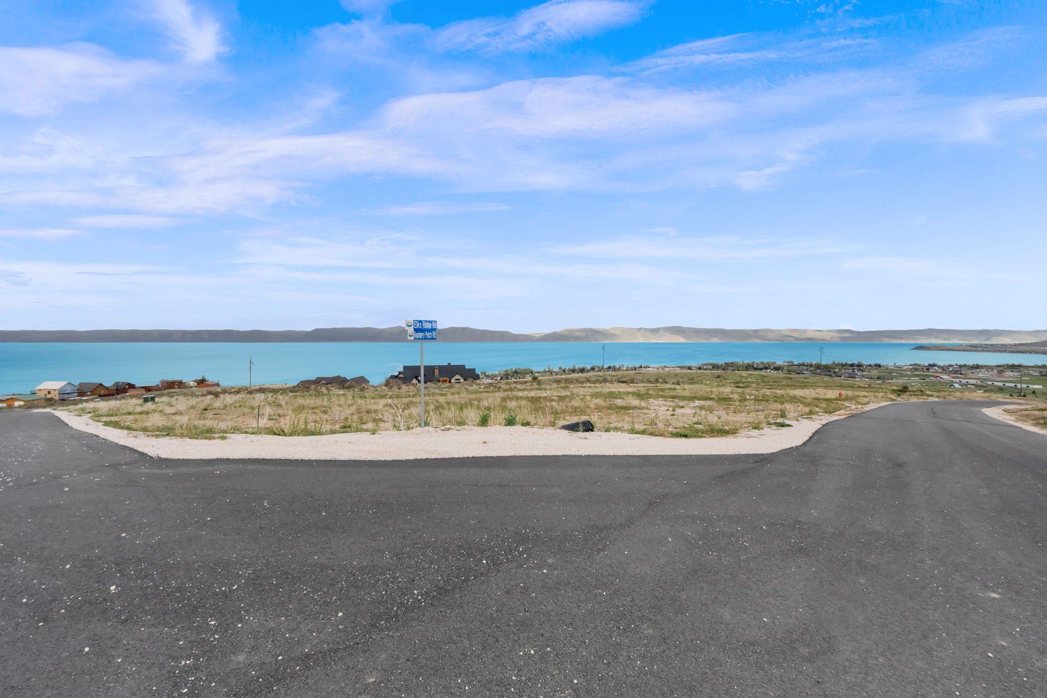 Paved road frontage with a water body backdrop