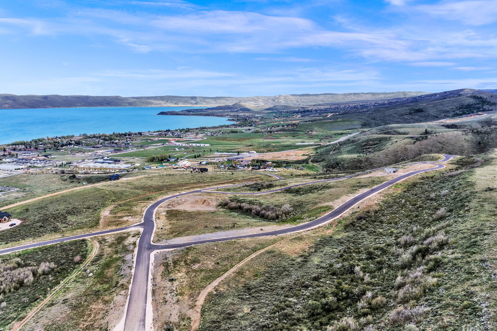 Expansive land parcel featuring paved roads, scattered residences, and mature vegetation