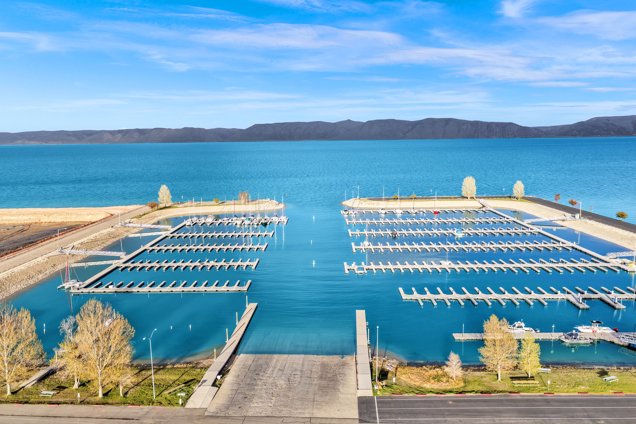 Expansive marina featuring multiple boat slips, a wide boat ramp, and direct water access
