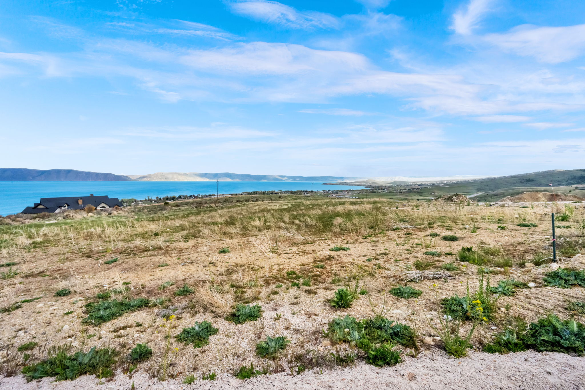 Expansive undeveloped terrain featuring broad horizons and a prominent body of water