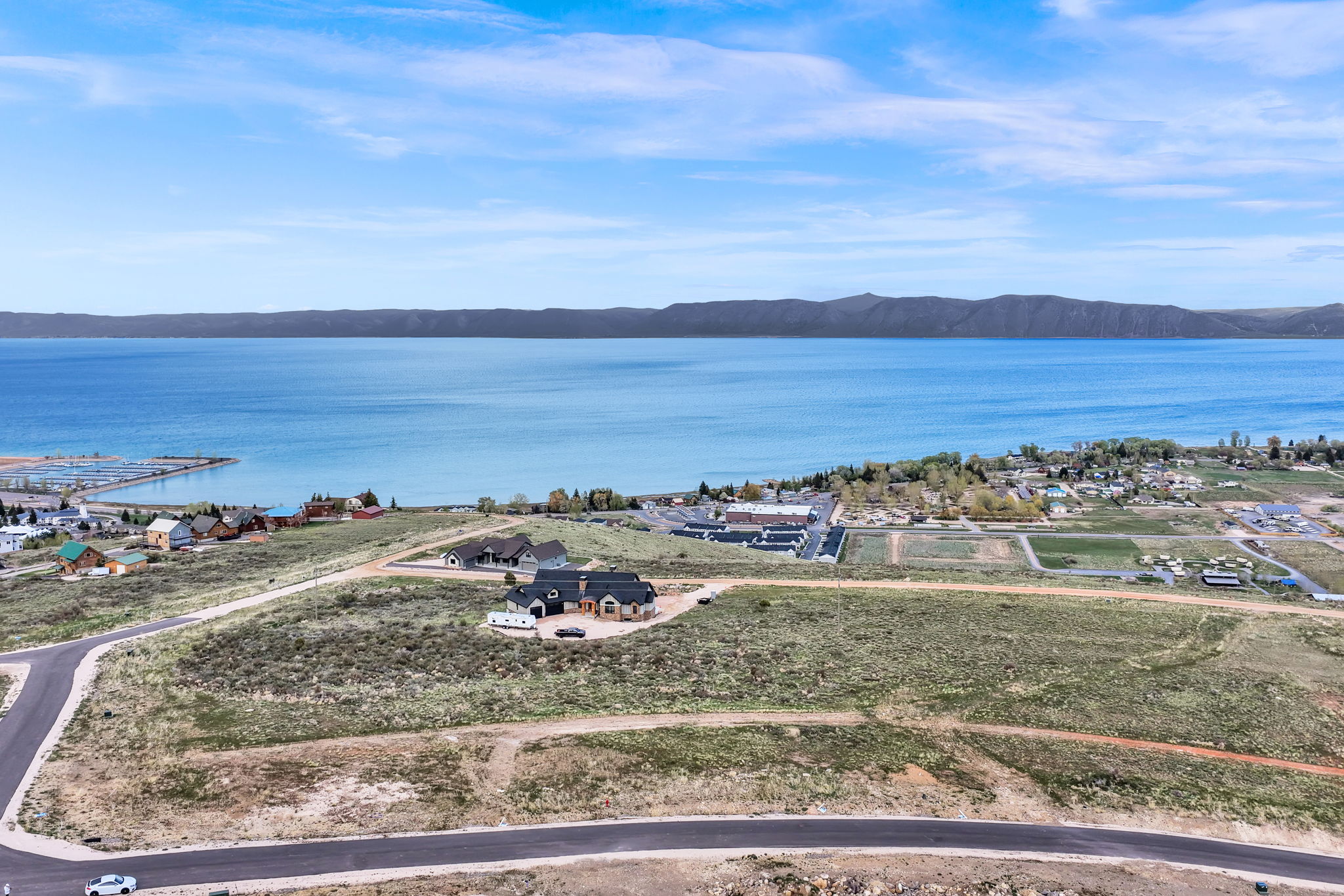 Expansive waterfront property with a residential structure, a private boat dock, and a mountainous backdrop
