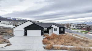 Ranch-style house with a mountain view, a residential view, an attached garage, and concrete driveway