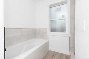 Full bathroom with a bath and light wood-type flooring