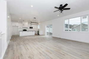 Unfurnished living room with light wood finished floors, a ceiling fan, and recessed lighting