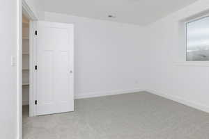 Unfurnished bedroom featuring carpet and a spacious closet
