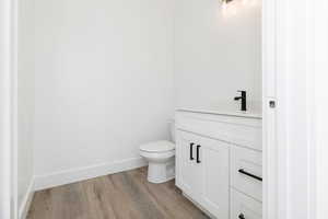 Half bath with vanity and light wood finished floors