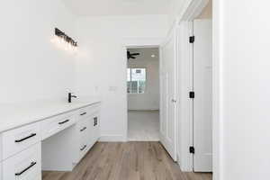 Bathroom featuring vanity, light wood-style floors, and a ceiling fan