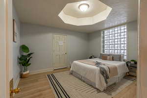 Bedroom with a textured ceiling and light wood-style floors