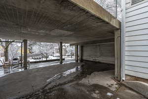 Snow covered patio with a garage