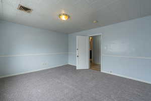 Empty room featuring carpet flooring and baseboards