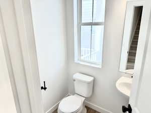Bathroom featuring toilet and wood finished floors (pictures of home previously built)