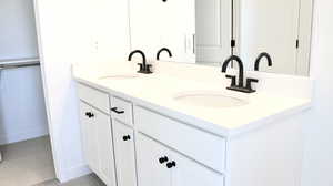 Bathroom with double vanity and baseboards (pictures of home previously built)