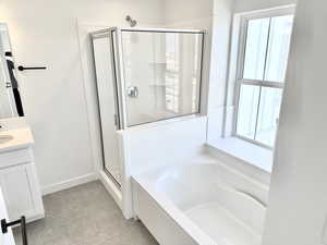 Full bathroom featuring a shower stall, a garden tub, plenty of natural light, and vanity (pictures of home previously built)