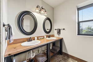 Bathroom featuring baseboards and double vanity