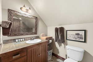 Bathroom with vanity, lofted ceiling, and a textured ceiling