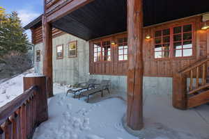 Snow covered property entrance with a patio area