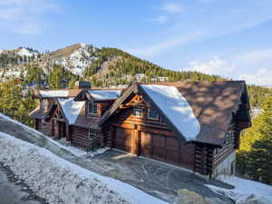 Log home featuring log siding, a chimney, and a mountain view