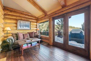Living area with hardwood / wood-style floors, french doors, and log walls