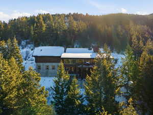 View of front of property featuring a chimney and a wooded view